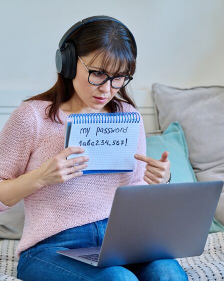 Middle-aged woman user typing password on laptop