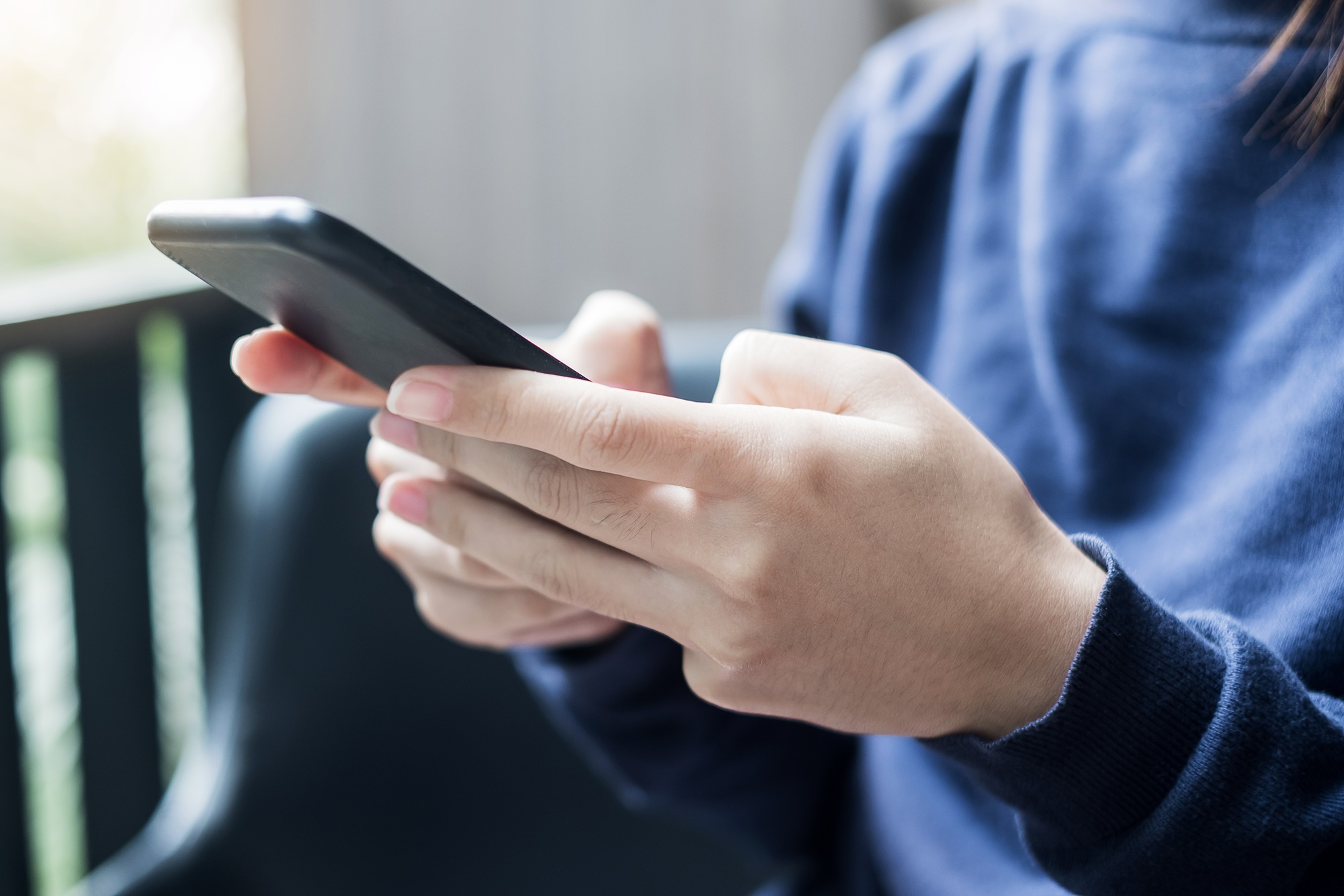 Businesswoman holding and using smartphone for sms messages