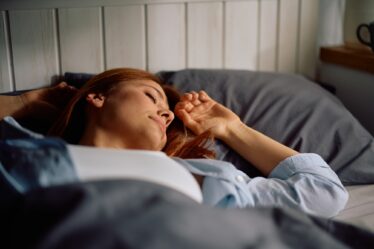 Relaxed woman enjoying in good night sleep in bedroom.