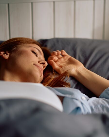 Relaxed woman enjoying in good night sleep in bedroom.